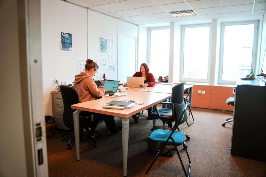 Deux salariés partagent un bureau fermé en coworking
