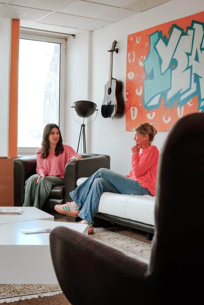 Discussion entre coworkers dans les canapés de l'espace repos du coworking