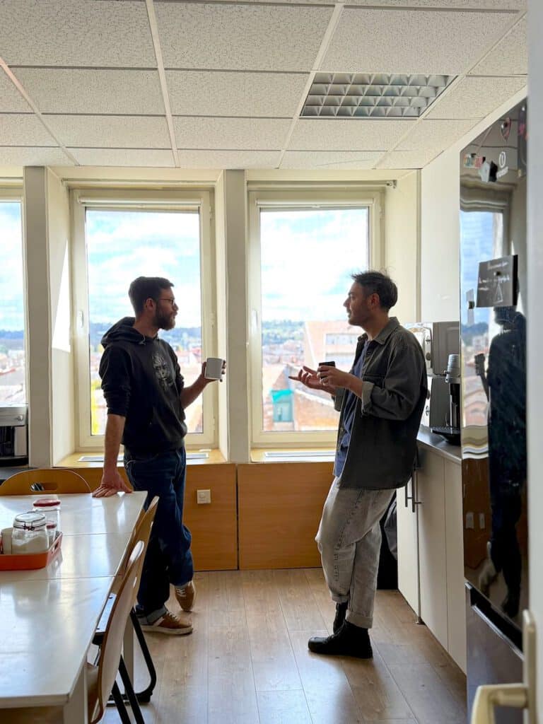 Deux habitants discutent dans la cuisine du coworking