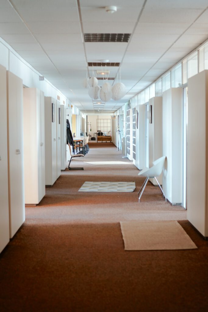 Couloir lumineux menant aux open spaces et aux bureaux du coworking